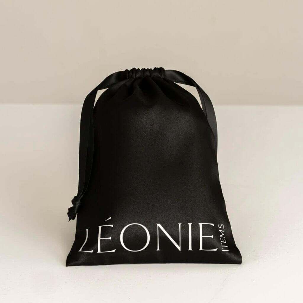 Svart resefodral för sidenprodukter med Léonie Items logga